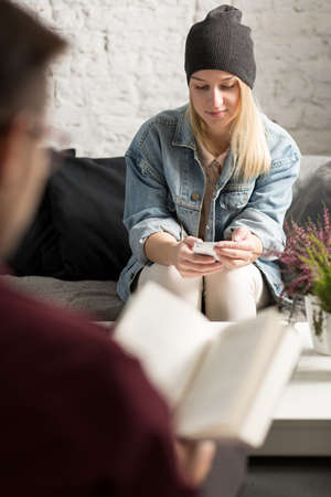 Young beautiful woman in cafe texting on phoneの写真素材