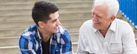 Young man sharing the music with his grandfatherの写真素材