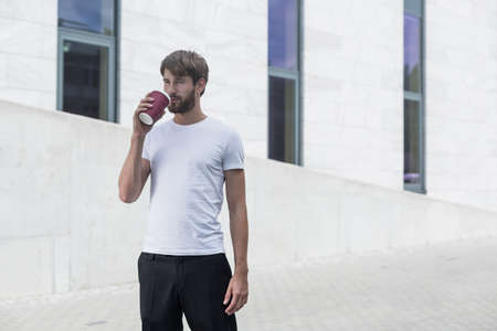 Young handsome man has coffee break at workの写真素材
