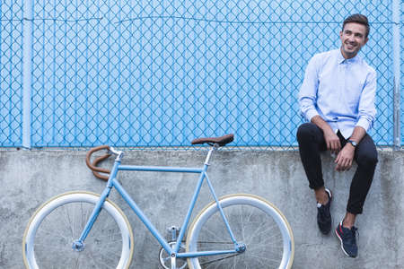 Horizontal view of handsome businessman with bikeの写真素材