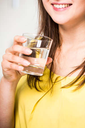 Close-up of woman drinking healthy clear waterの写真素材