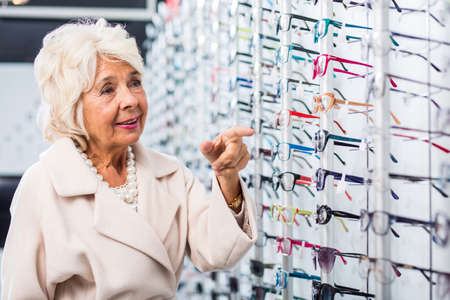 Female retiree looking for new reading eyeglassesの写真素材