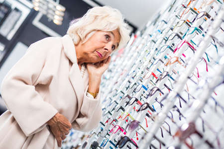 Worried senior woman staying in optical shopの写真素材
