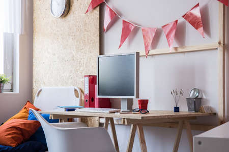 Desk with desktop computer in teen roomの写真素材