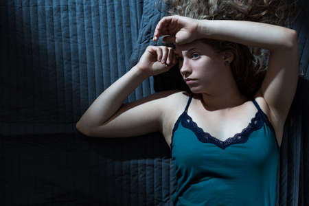 Image of tired female relaxing in bedroomの写真素材