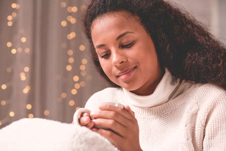Cold African American woman with tea cup