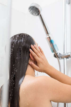 Image of brunette woman relaxing under shower
