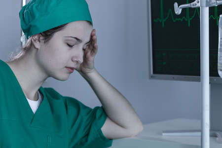 Picture of exhausted female surgeon during shift on emergency departmentの写真素材
