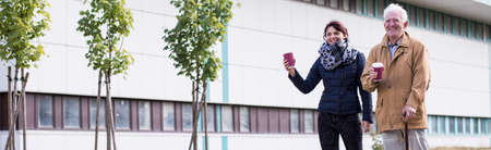 Disable father and daughter are drinking take-away coffeeの写真素材