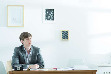 Photo of bethinking young male designer working on new project