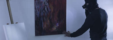 Thief wants to rip off a piece of artの写真素材