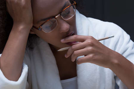 Tired black African girl yawning while learningの写真素材