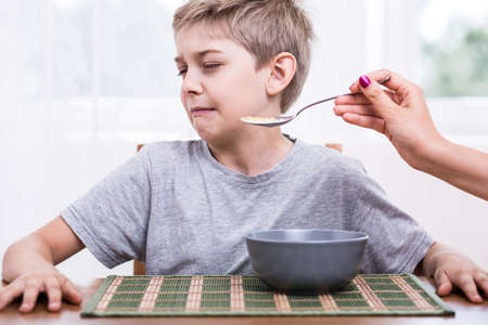 Picky eater boy refusing to eat disgusting foodの写真素材