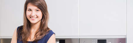 Young happy pretty girl in the kitchenの写真素材