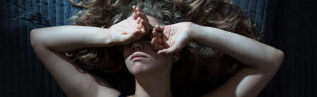 Woman in bed has headache because of insomniaの写真素材
