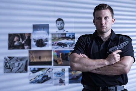 Young muscular man is posing with gunの写真素材