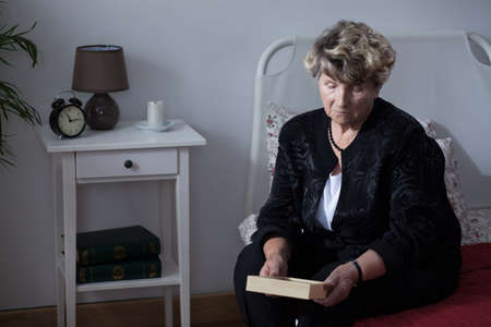 Photo of elderly woman mourning her dead husband