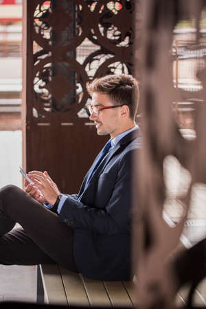 Man with tablet sitting on the bench