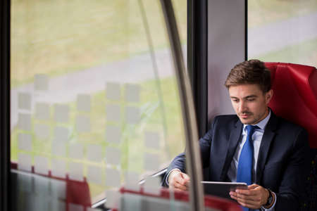 Busy businessman working during way to workの写真素材