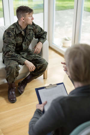 Image of man in military uniform and his psychotherapistの写真素材