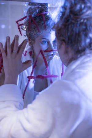 Teenage girl watching herself in the mirrorの写真素材