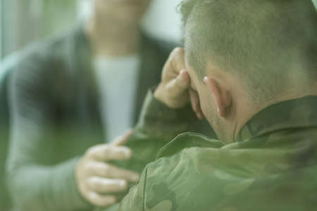 Image of female therapist supporting her military patientの写真素材
