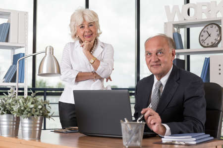 Elderly businessman and businesswoman working in officeの写真素材