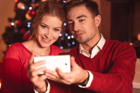 Image of happy couple doing christmas selfieの写真素材