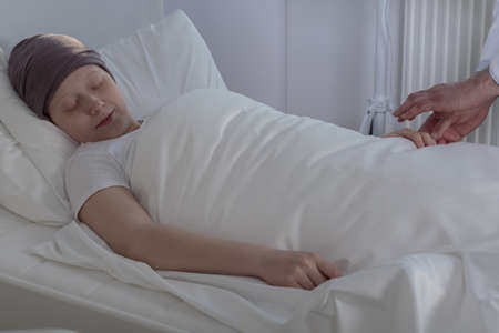 Girl with cancer sleeping in hospital bedの写真素材