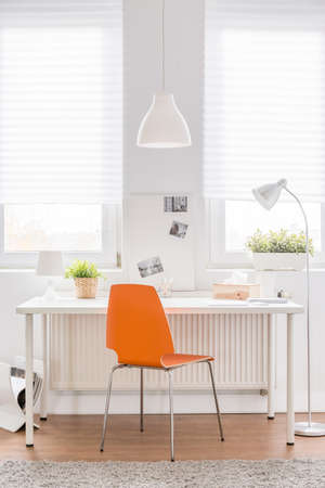Image of white desk with new orange chairの写真素材