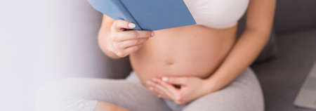 Pregnant woman touching belly and reading woman