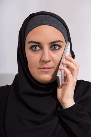 Headshot of young arab girl talking on the phoneの写真素材