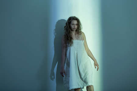 Scared young assaulted woman in empty roomの写真素材