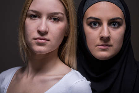 Serious faces of european and arab womenの写真素材