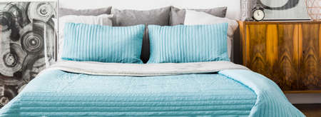 Turquoise cushions and bedspread on double bed