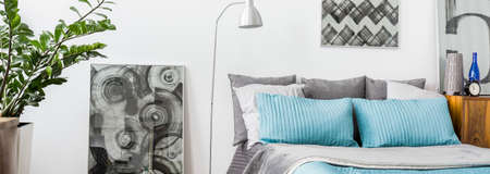 Modern bedroom with grey and turquoise decorationsの写真素材