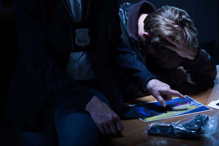 Police officer is pointing at the picture of victimの写真素材