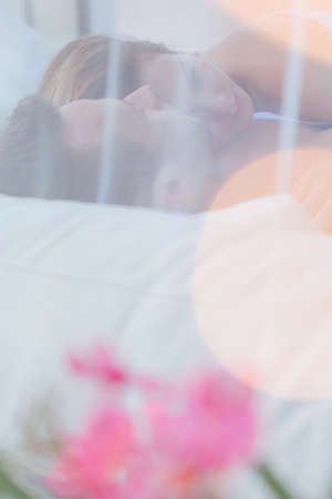 Romantic couple in love cuddling in bedの写真素材