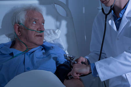 Recovering senior patient examined by doctor in hospitalの写真素材