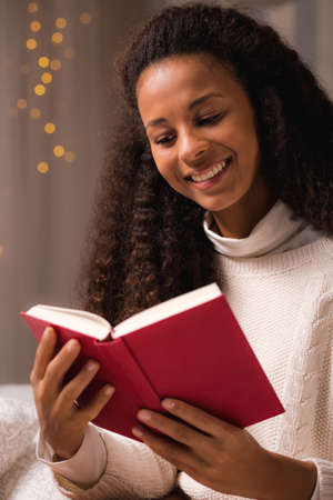 Image of beautiful woman in cosy interior enjoying book