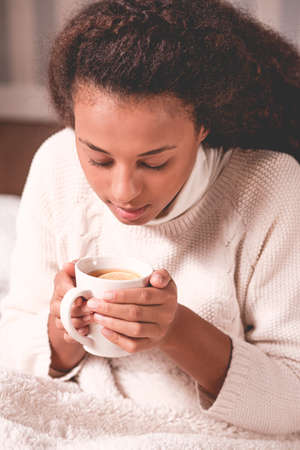 Image of girl with cup of tea heating cold hands