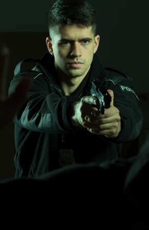Young armed policeman with gun and self defense
