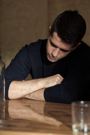 Young man is tired after too much drinkingの写真素材