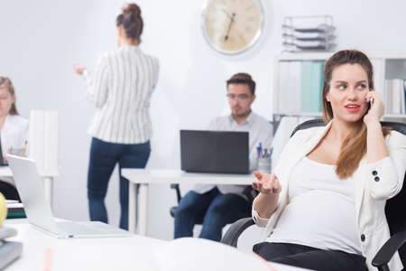 Young businesswoman working in corporation during pregnancy in corporationの写真素材