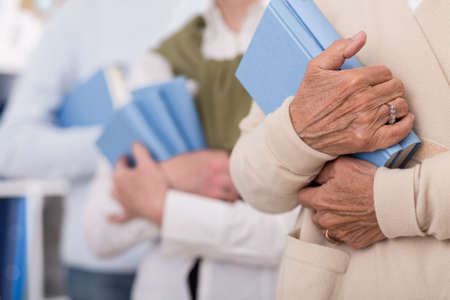 Senior people holding books in blue coverの写真素材