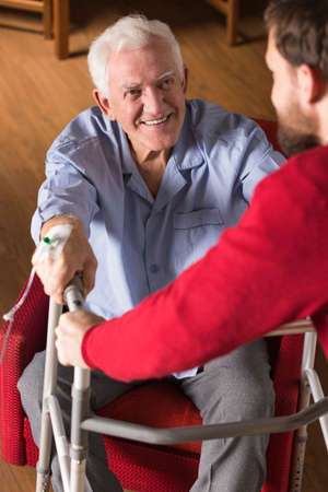 Picture of son helping old disabled fatherの写真素材