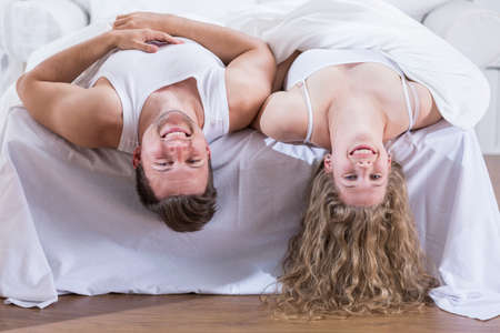 Young happy couple is goofing in bed