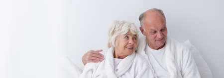 Old couple is smiling in the bedの写真素材