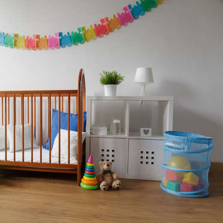 Photo of simple design wooden cradle in cosy baby bedroomの写真素材