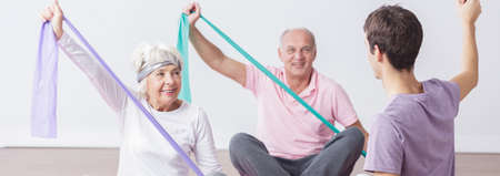 Two elder people are exercising in the gym